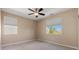 An empty bedroom with neutral walls, a ceiling fan, and a window providing natural light and a scenic view at 4212 Hawks Glide Ave, North Las Vegas, NV 89084