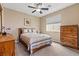 This bedroom features a cozy bed with wooden dresser, ceiling fan and lots of natural light at 4212 Hawks Glide Ave, North Las Vegas, NV 89084
