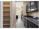 Stylish kitchen showcasing dark cabinets, granite countertops, and a convenient pantry for storage at 4212 Hawks Glide Ave, North Las Vegas, NV 89084