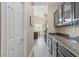 Hallway featuring a kitchen with granite counters, and dark wood cabinets at 4212 Hawks Glide Ave, North Las Vegas, NV 89084