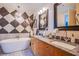 Elegant bathroom featuring a soaking tub, granite counters, and stylish black and white decor at 4525 Dean Martin Dr # 1103, Las Vegas, NV 89103