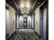 Elegant elevator lobby with a chandelier, patterned carpet, and decorative wall sconces at 4525 Dean Martin Dr # 1103, Las Vegas, NV 89103