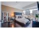 Modern main bedroom with a city view, dark wood floors, and a padded headboard at 4525 Dean Martin Dr # 1103, Las Vegas, NV 89103