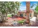 Cozy backyard featuring a covered patio, mature trees, and drought-tolerant landscaping at 731 Rising Star Dr, Henderson, NV 89014