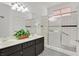 Modern bathroom with tiled shower, glass block window, and a double sink vanity at 731 Rising Star Dr, Henderson, NV 89014