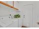 Well-lit laundry area featuring modern appliances, overhead cabinets and wood flooring at 731 Rising Star Dr, Henderson, NV 89014