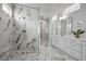 Modern bathroom featuring marble tile, glass shower, and a dual sink vanity at 8440 Footpath St, Las Vegas, NV 89166