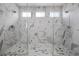 Luxurious bathroom with marble tile, glass shower doors, and dual shower heads at 8440 Footpath St, Las Vegas, NV 89166