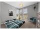 Cozy bedroom featuring natural light, a stylish chair, and a comfortable plaid-covered bed at 8440 Footpath St, Las Vegas, NV 89166