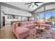 Open living space with a pink sectional sofa, view of kitchen, and natural light at 8440 Footpath St, Las Vegas, NV 89166