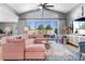 The open living room showcases a vaulted ceiling, oversized glass doors, and a cozy sectional couch at 8440 Footpath St, Las Vegas, NV 89166