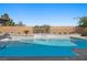 Sparkling backyard pool with a modern waterfall feature under a clear blue sky at 8440 Footpath St, Las Vegas, NV 89166