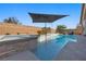 Modern backyard pool with a spa, waterfall, and desert landscaping at 8440 Footpath St, Las Vegas, NV 89166