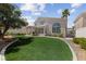 Backyard featuring an artificial grass lawn and a covered patio, ideal for outdoor living at 3024 Pismo Beach Dr, Las Vegas, NV 89128