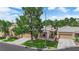 Front of home features desert landscaping, mature trees, and a well-manicured lawn at 328 Wild Plum Ln, Las Vegas, NV 89107