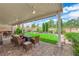 Spacious backyard with lush lawn, manicured landscaping, and covered patio seating area ideal for entertaining at 328 Wild Plum Ln, Las Vegas, NV 89107