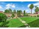 Lush backyard with manicured lawn, stone pathway, and mature trees create a serene outdoor space at 328 Wild Plum Ln, Las Vegas, NV 89107