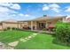 Well-maintained backyard with a lush lawn, landscaped garden, and covered patio for outdoor entertaining at 328 Wild Plum Ln, Las Vegas, NV 89107