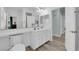 Bright bathroom with white cabinetry, tile counters, and wood-look flooring creates a clean, modern space at 328 Wild Plum Ln, Las Vegas, NV 89107