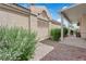 Side of home with covered patio, grill, small yard with desert landscaping, and stone walkway at 328 Wild Plum Ln, Las Vegas, NV 89107