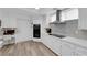 Modern kitchen with white cabinets, stainless steel appliances, desk area and wood look flooring at 328 Wild Plum Ln, Las Vegas, NV 89107