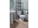 Bathroom featuring pedestal sink, tiled floors, and a metal over-the-toilet shelf at 4590 Lime Straight Dr, Las Vegas, NV 89115
