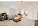 Bright living room featuring a comfortable sectional, neutral carpet, and a view into the dining area at 5114 Mascaro Dr, Las Vegas, NV 89122