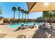 Community pool with lounge chairs, palm trees, and sunshade at 7633 Tender Tassels St, Las Vegas, NV 89149