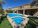 Beautiful backyard with a sparkling pool and spa, artificial grass, and desert landscaping at 8303 Saddleback Ledge Ave, Las Vegas, NV 89147