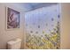 Bright bathroom featuring a floral shower curtain, decorative art, and a starfish accent on the toilet at 8303 Saddleback Ledge Ave, Las Vegas, NV 89147