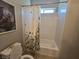 Standard bathroom features a tub shower with decorative curtain, toilet, and neutral colored walls at 8303 Saddleback Ledge Ave, Las Vegas, NV 89147