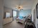 Charming bedroom with light blue walls, a ceiling fan, and a twin bed adorned with decorative pillows at 8303 Saddleback Ledge Ave, Las Vegas, NV 89147