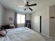 Neutral bedroom with a ceiling fan, large bed with decorative pillows, and a double door closet at 8303 Saddleback Ledge Ave, Las Vegas, NV 89147