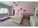 Pink bedroom with decorative flowers on the wall, a bed, and a gymastic bar in the corner at 8303 Saddleback Ledge Ave, Las Vegas, NV 89147