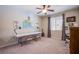 Bright bedroom featuring neutral carpet, ceiling fan, a large window, and a spacious desk area at 8303 Saddleback Ledge Ave, Las Vegas, NV 89147