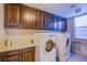 Efficient laundry room featuring front-loading washer/dryer and upper cabinets for ample storage solutions at 8303 Saddleback Ledge Ave, Las Vegas, NV 89147