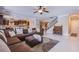 Inviting living room featuring a comfortable brown sectional, modern ceiling fan and an open concept kitchen at 8303 Saddleback Ledge Ave, Las Vegas, NV 89147