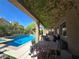 Inviting covered patio with outdoor dining and seating area overlooking the sparkling pool and landscaped yard at 8303 Saddleback Ledge Ave, Las Vegas, NV 89147