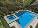 Aerial view of a sparkling blue pool and spa surrounded by a well-manicured backyard at 8303 Saddleback Ledge Ave, Las Vegas, NV 89147