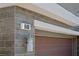 Close-up of the exterior showing the house number on the gray wood-look tile and garage door at 888 Cherry Glen Pl, Las Vegas, NV 89138