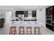 Modern kitchen with an island, stainless steel appliances, dark cabinets, and stylish bar stool seating at 888 Cherry Glen Pl, Las Vegas, NV 89138