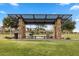 Open park pavilion with stone pillars, geometric metal covering, picnic tables, trash can, and landscaping at 888 Cherry Glen Pl, Las Vegas, NV 89138