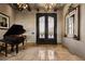 Grand foyer with a striking iron door, travertine flooring, and elegant piano at 1123 Christian Rd, Henderson, NV 89002