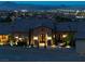 Luxury stone home entrance with double doors, manicured landscaping, and illuminated walkway at 1123 Christian Rd, Henderson, NV 89002