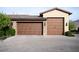 Attached two-car garage with wooden doors, stone accents, and a paved driveway at 1123 Christian Rd, Henderson, NV 89002