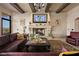 Cozy living room with a stone fireplace, comfortable leather sofa, and exposed wood beams at 1123 Christian Rd, Henderson, NV 89002