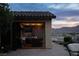 Chic outdoor kitchen showcasing stone backsplash, dark cabinets, and access to an outdoor stone patio at 1123 Christian Rd, Henderson, NV 89002