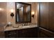 Tastefully decorated powder room with custom vanity, granite countertop, and sconce lighting at 1123 Christian Rd, Henderson, NV 89002
