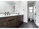 Modern bathroom featuring double sinks, sleek dark cabinets and a separate toilet room at 11990 Montague St, Las Vegas, NV 89138
