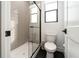 Bathroom featuring a glass-enclosed shower, toilet and sleek black and white design at 11990 Montague St, Las Vegas, NV 89138